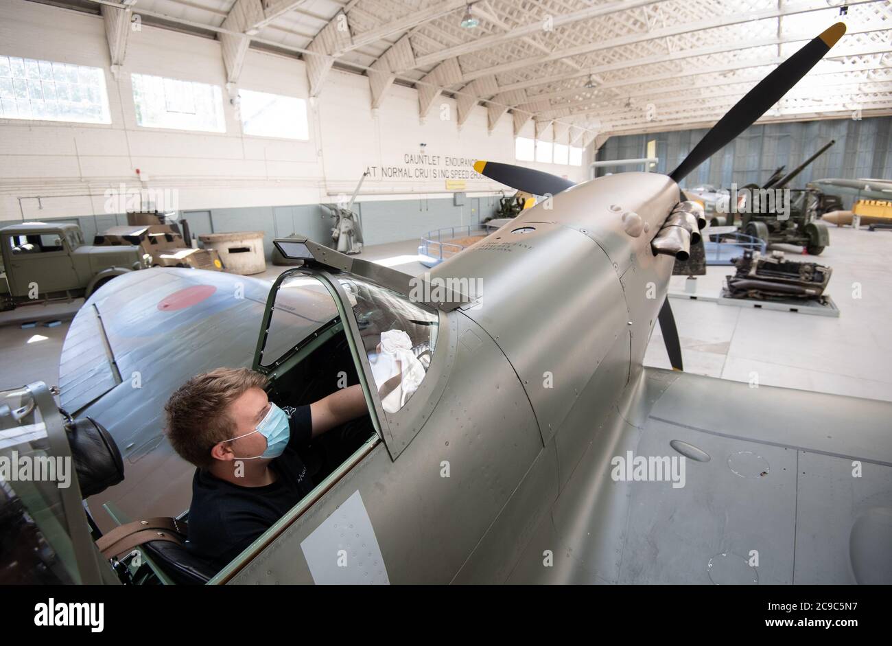 Engineer Joe Malkin from the Aircraft Restoration Company cleans the canopy of a Supermarine Spitfire at the Imperial War Museum Duxford as the attraction prepares to reopen to the public on Saturday following the easing of lockdown restrictions in England. Stock Photo