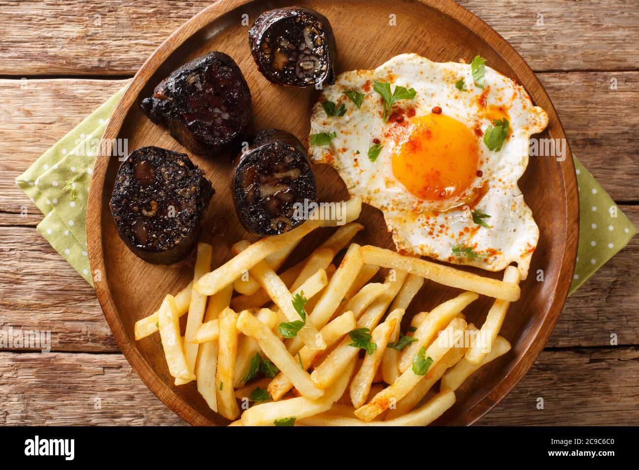 Huevos Rotos Recipe: Spanish Broken Eggs with potato and blood sausage close-up in a plate on the table. Horizontal top view from above Stock Photo