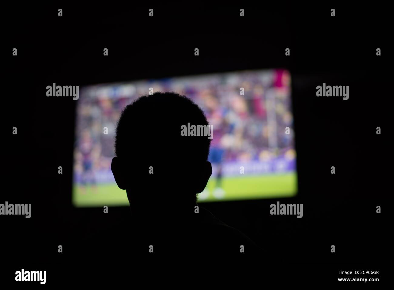 Person watching television in dark room Stock Photo