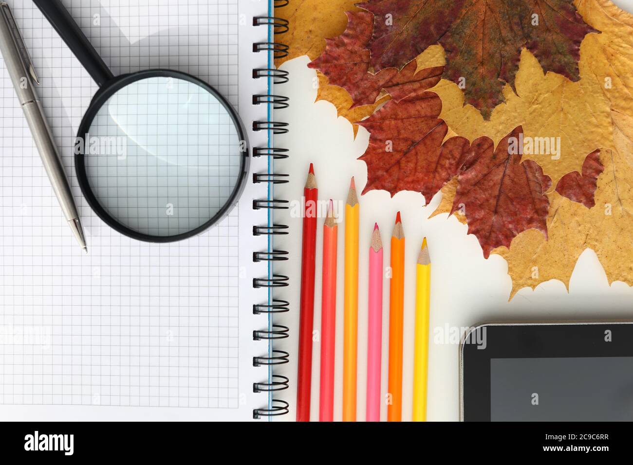 On the table is a tablet and colored pencils Stock Photo