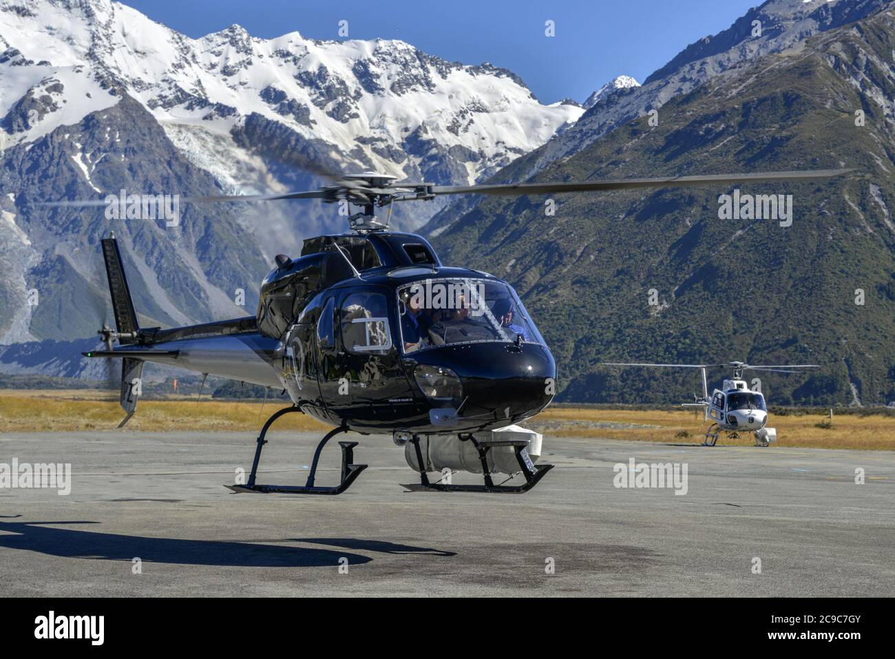 A Eurocopter AS350 Squirrel helicopter at work in an alpine setting Stock Photo