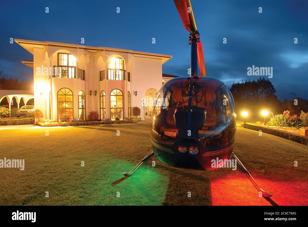A Robinson R44 helicopter at dusk, on the grass beside Bonshaw Park, a boutique hotel in Taupo NZ. Stock Photo