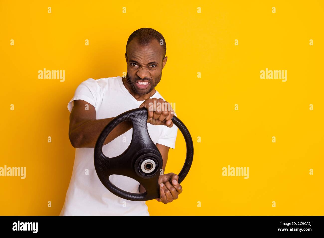 Photo of attractive dark skin guy man trying hard to turn car left