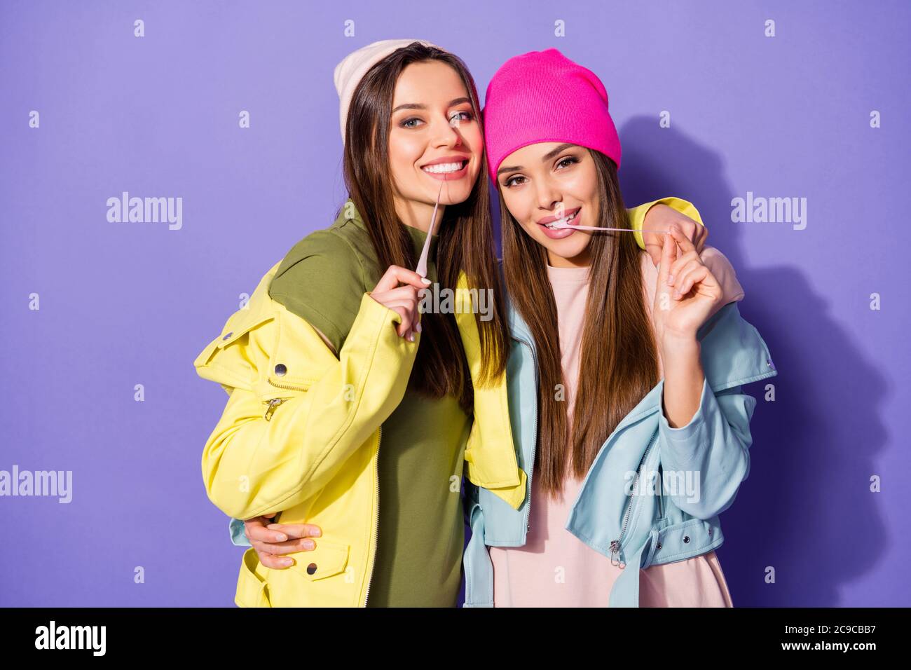 Close-up portrait of nice-looking attractive lovely playful cheerful cheery girls chewing guns having fun fooling isolated over bright vivid shine Stock Photo