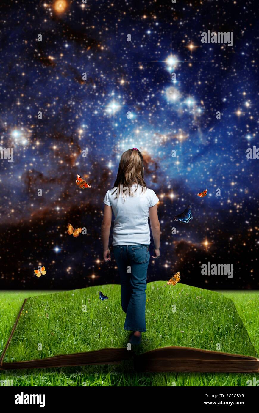 girl in white shirt walking on a green open book with universe and stars in the background - future generations and ecology concept Stock Photo