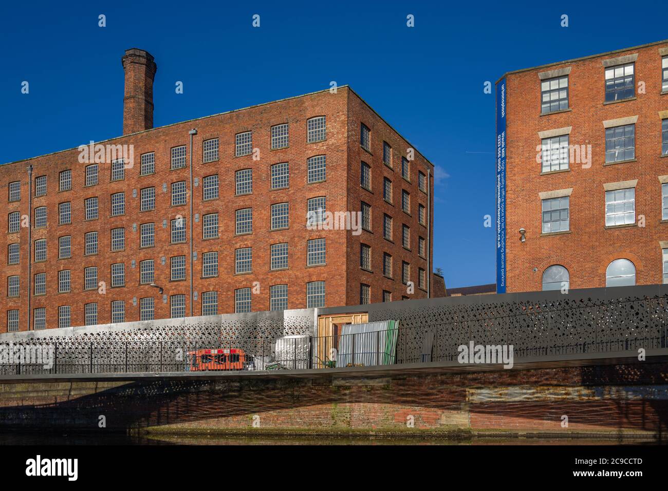 Murrays' Mills to the left. Shows iconic red brick, vast windows and mill chimney in building begun in 1797. Now apartments. Stock Photo