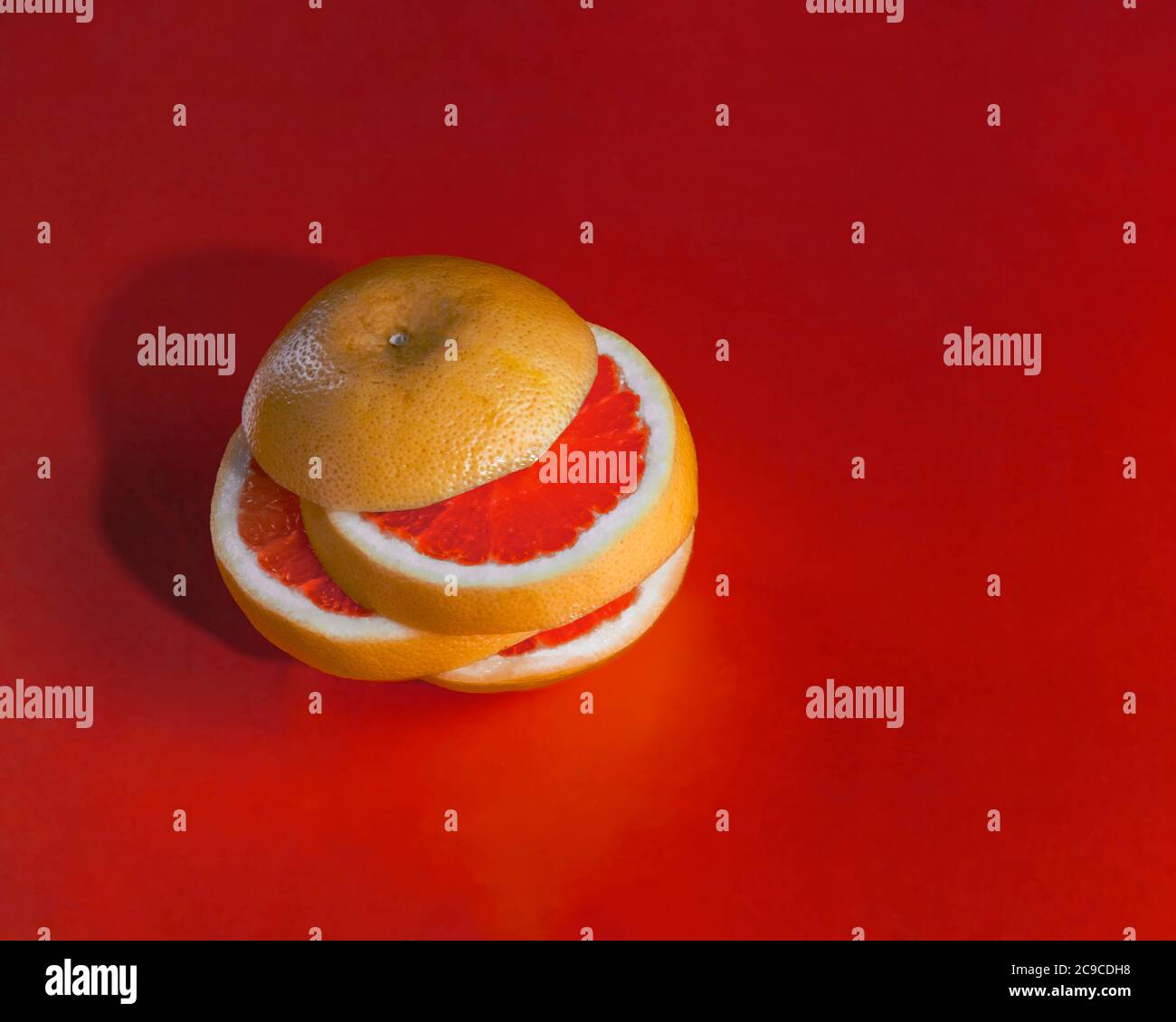 Sliced grapefruit tower isolated on red background Stock Photo