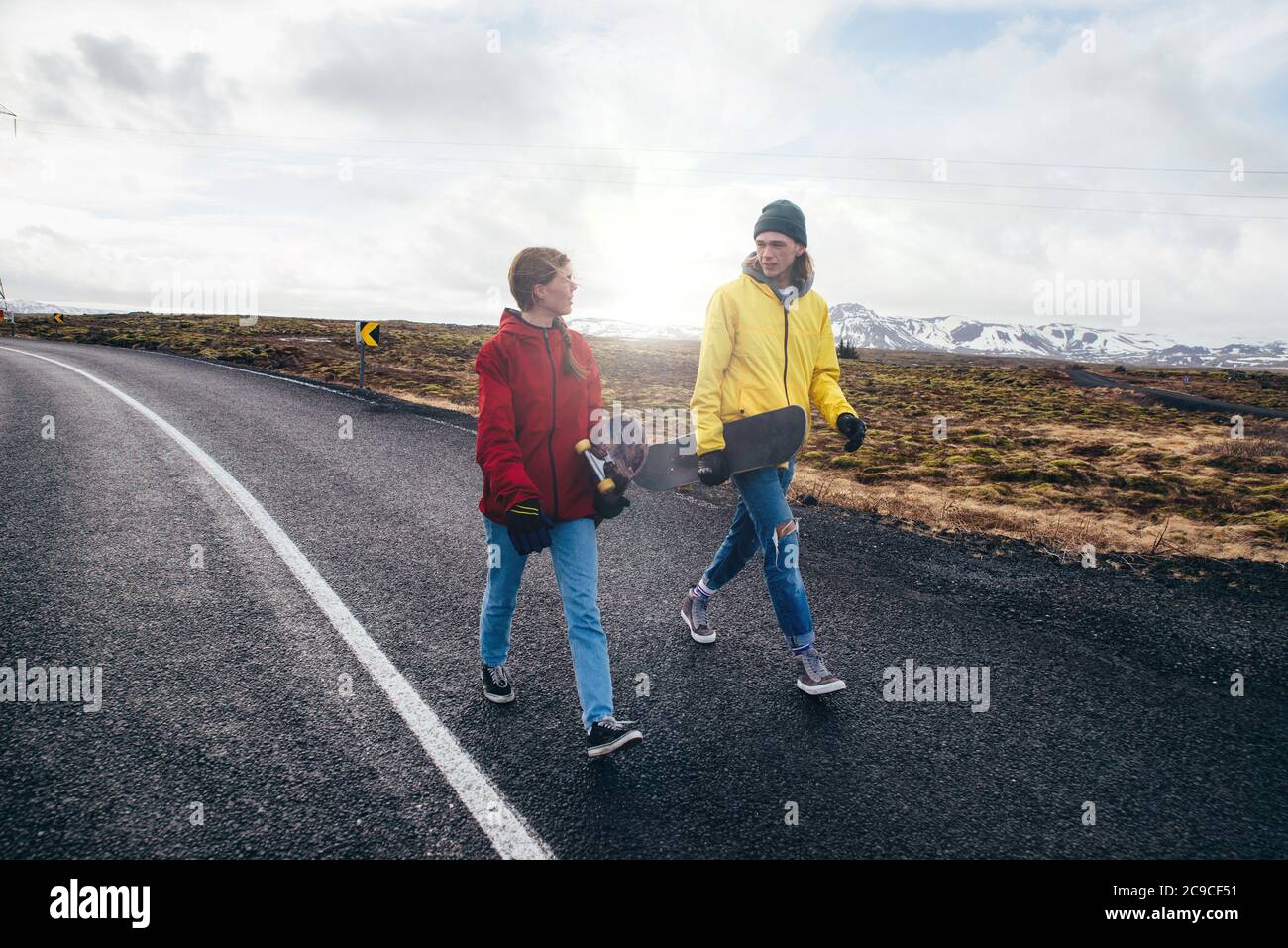 Couple of teenagers having fun skating and making downhill in Iceland Stock Photo