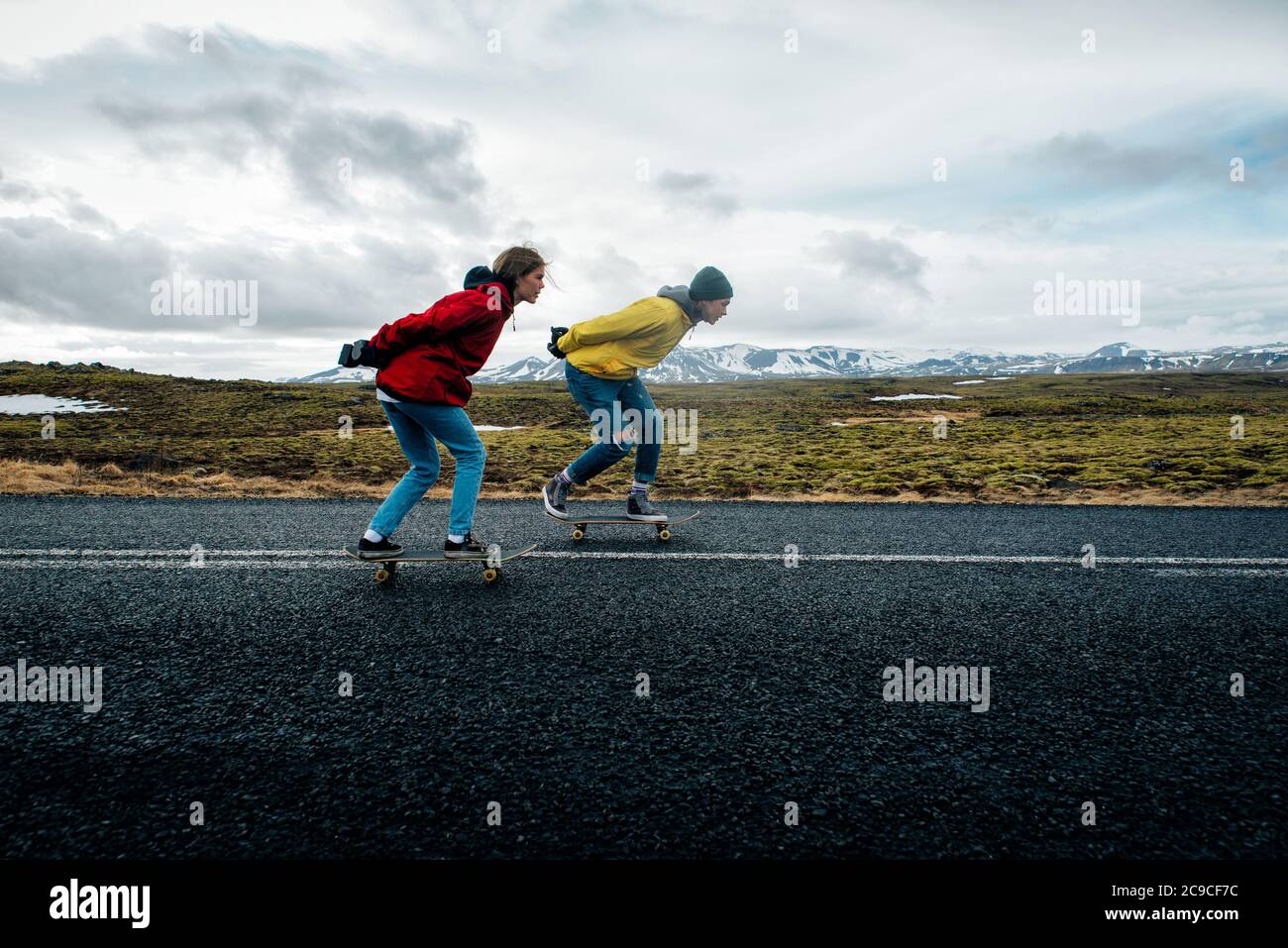 Couple of teenagers having fun skating and making downhill in Iceland Stock Photo