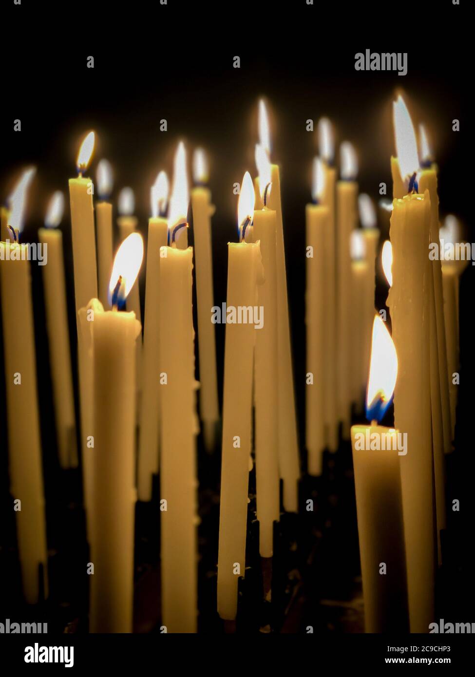 burning candle sticks over black with copy space in a church Stock
