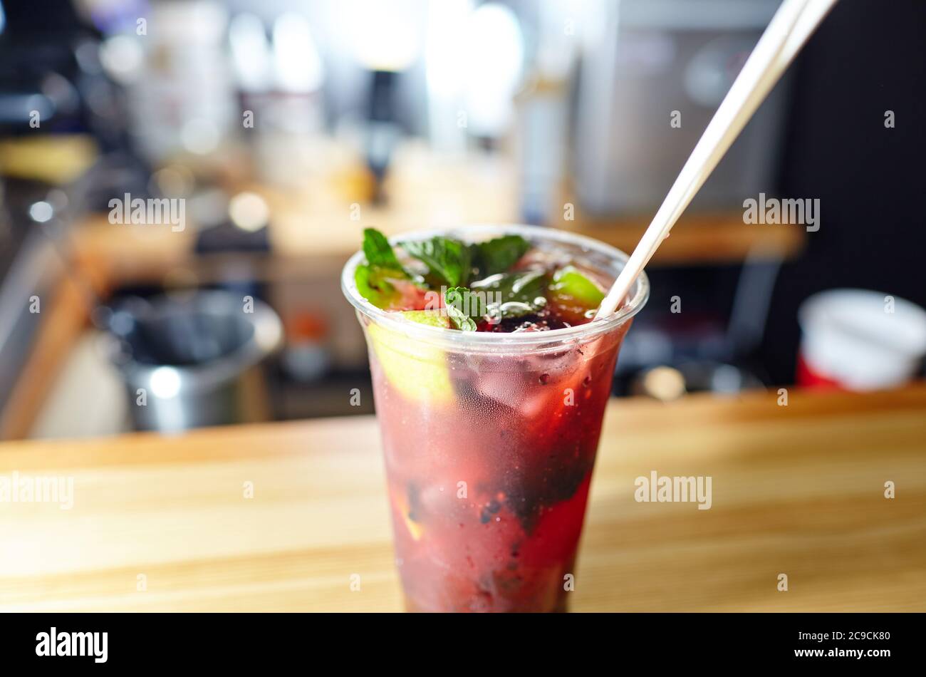 Mojito cocktail or soda drink with lime,raspberry and mint on table in bar.Blurred image,selective focus Stock Photo