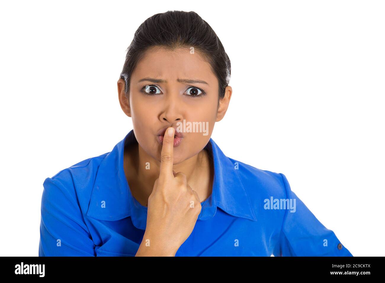 Closeup of a serious woman placing finger on lips, quiet, silence gesture isolated on white background. Human face expressions, signs, body language Stock Photo