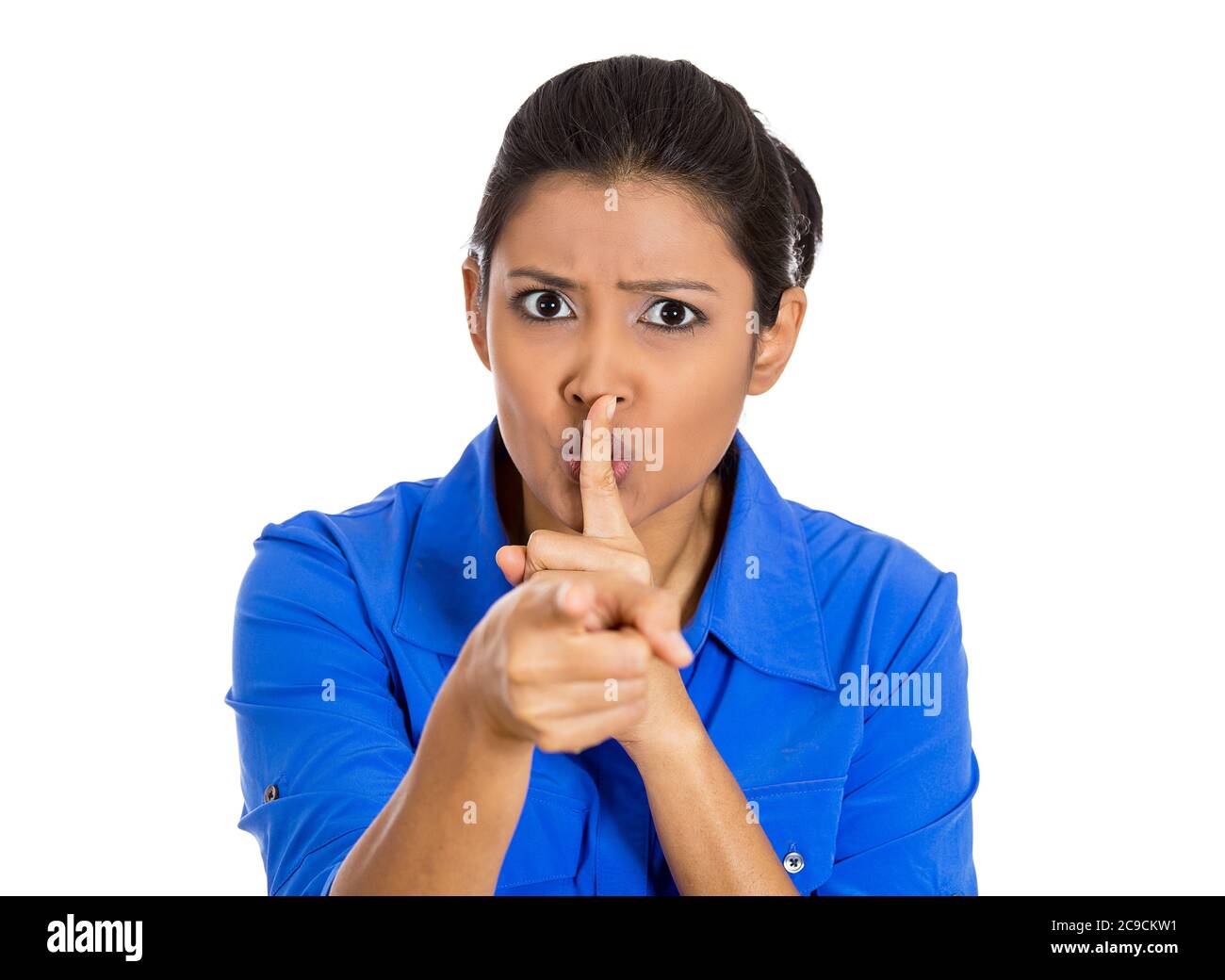 Closeup of a serious woman placing finger on lips, pointing at you quiet, silence isolated on white background. Human face expressions, signs, body la Stock Photo
