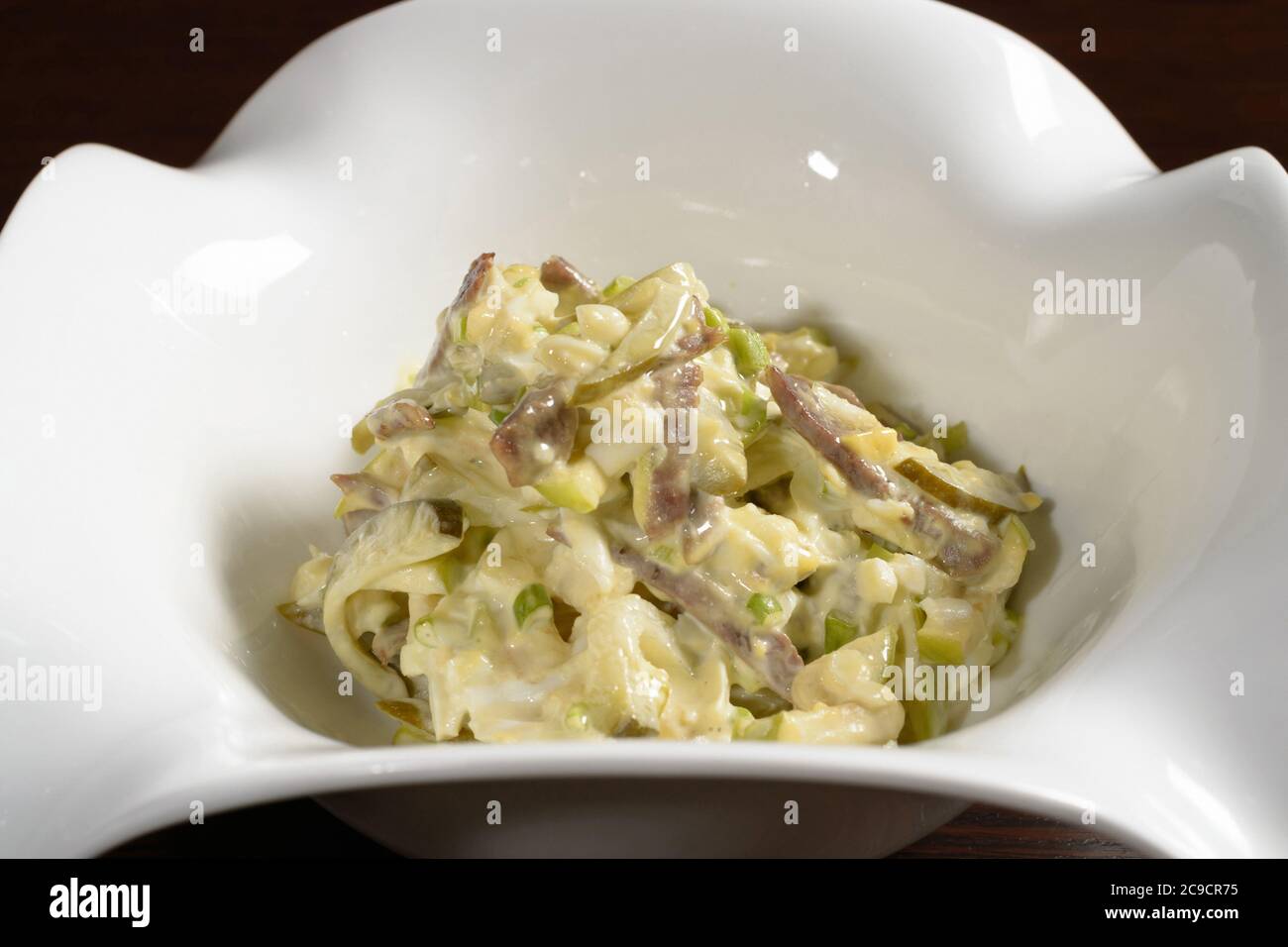 Salad served in the restaurant bacon with pickles seasoned with mayonnaise, close up. Photos for restaurant and cafe menus Stock Photo