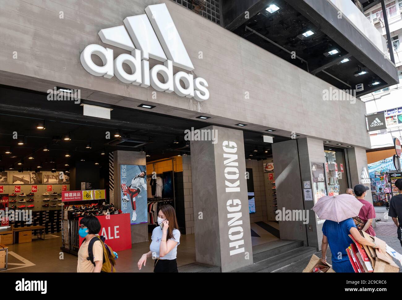 Hong Kong, China. 15th July, 2020. Pedestrians walk past German  multinational sportswear clothing brand, Adidas logo in Hong Kong. Credit:  Miguel Candela/SOPA Images/ZUMA Wire/Alamy Live News Stock Photo - Alamy