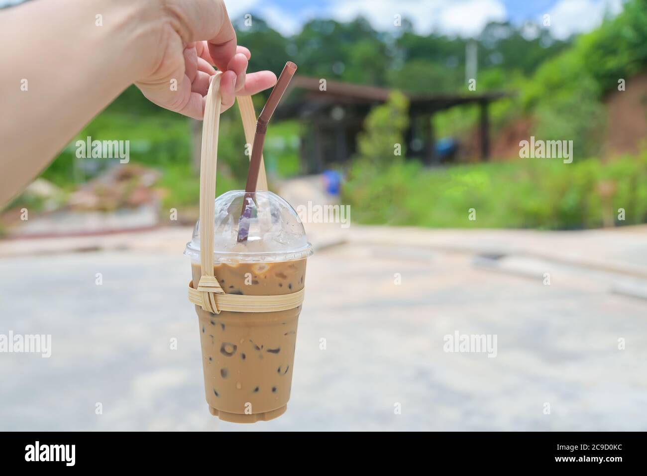 Hand holding a glass of iced coffee with bamboo tote carry for takeaway , save world ,Plastic bag free day Stock Photo