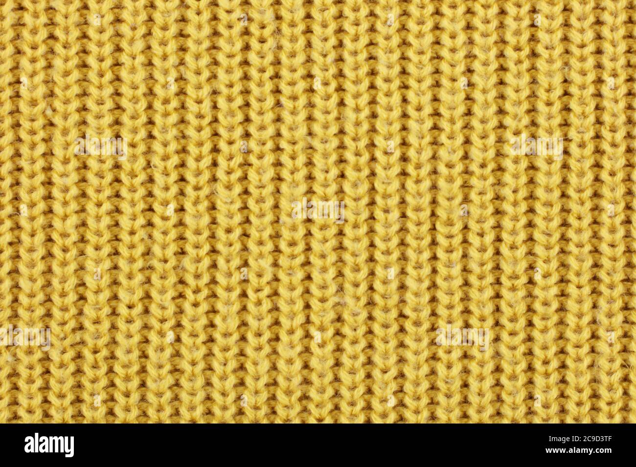 Yellow knitted ribbed wool textile background texture Stock Photo