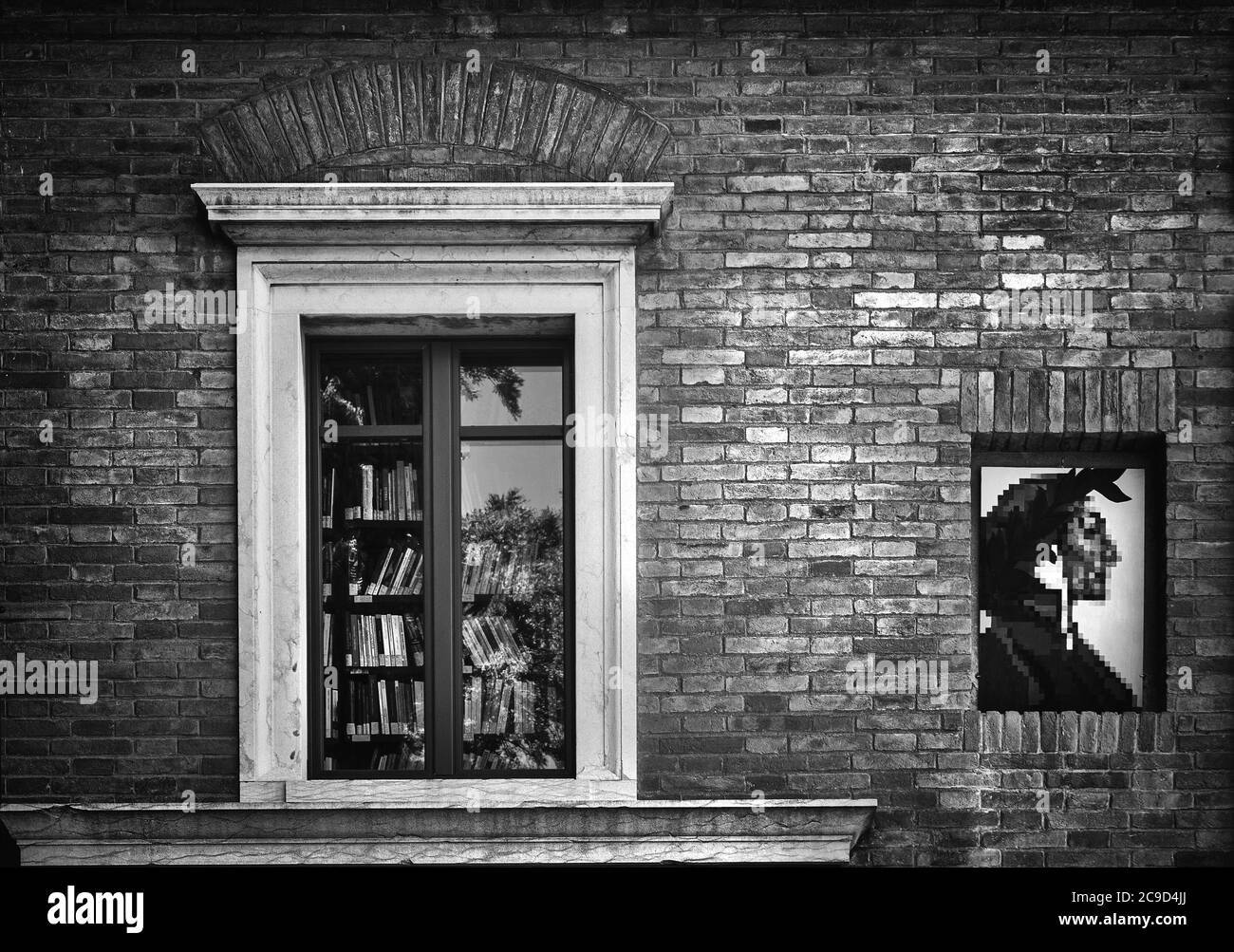 Ravenna, Italy.  July 28, 2020. the window with a bookcase inside with a depiction of Dante Alighieri on the wall of a house Stock Photo