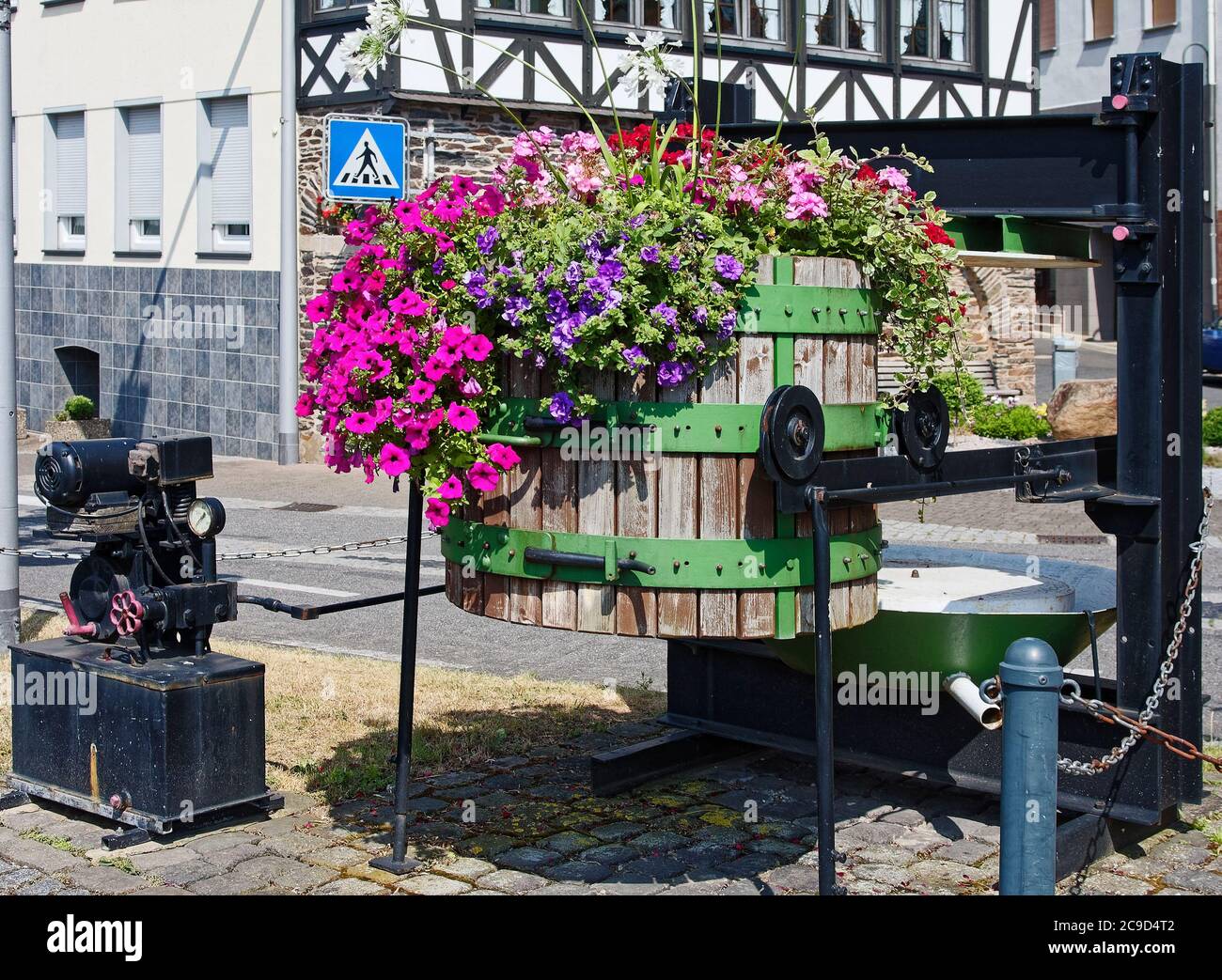 old wine making equipment, outside decorations, colorful flowers in wine barrel, street, cityscape, Europe, Zell; Germany Stock Photo