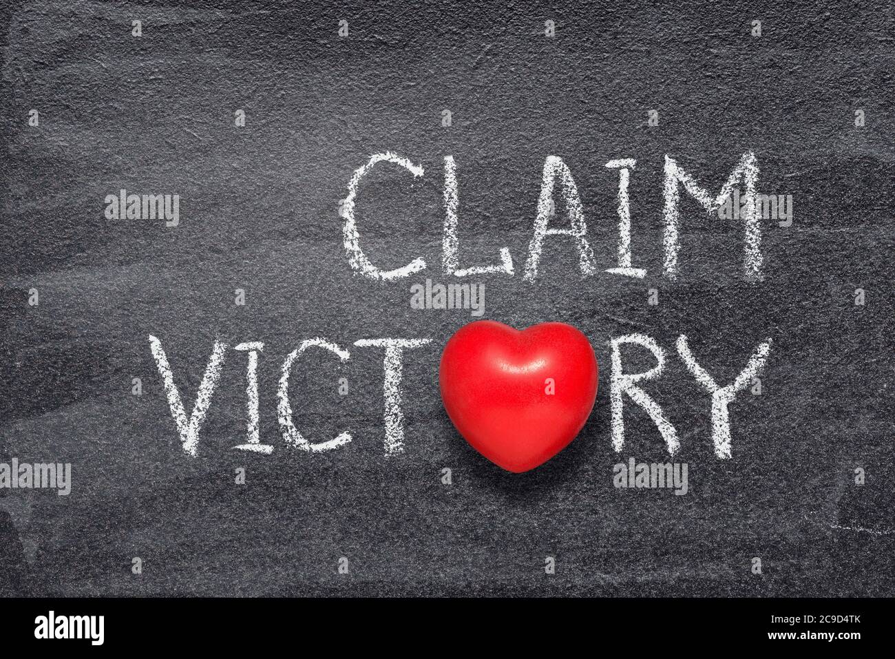 claim victory phrase written on chalkboard with red heart symbol Stock Photo