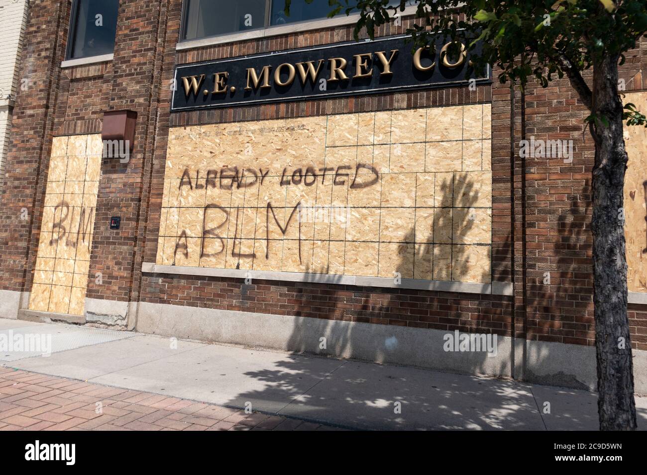 Business wanting to avoid destruction of building covered windows with plywood and claimed 'Already Looted'. St Paul Minnesota MN USA Stock Photo