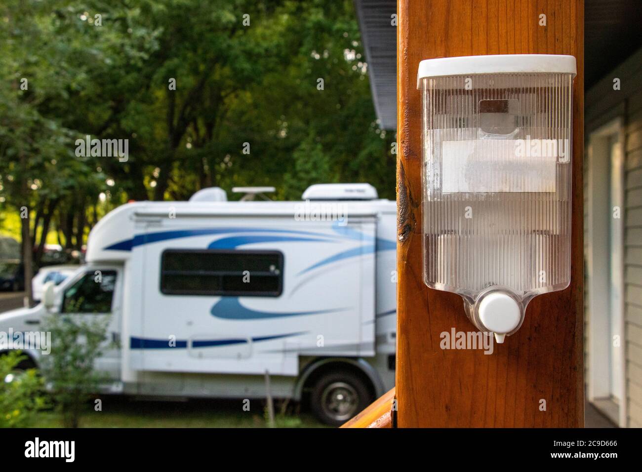Hand Sanitizer Dispenser at Sanitary block entrance on a campground during COVID-19 Coronavirus Pandemic, sanitary measures Stock Photo
