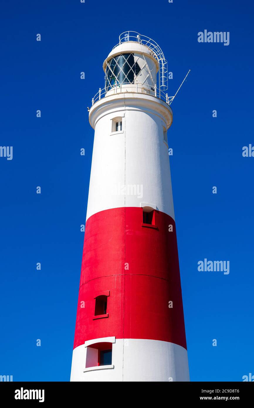 Lighthouse red and white striped tower at Portland Bill, Dorset, England, UK. Lighthouse close up photo taken in summer against a blue sky. Stock Photo