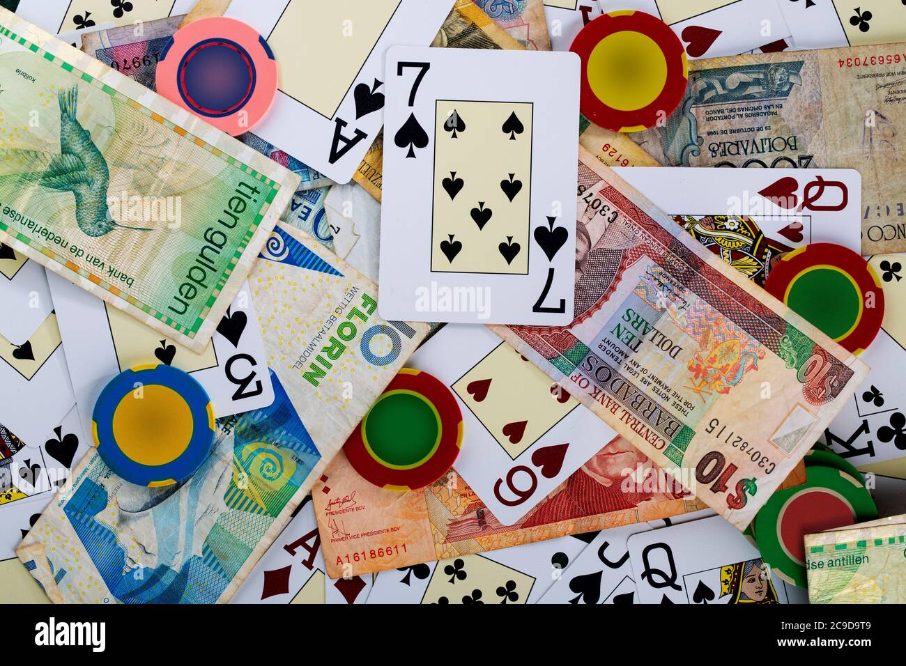 Deck cards on casino table with betting chips and money from different countries Stock Photo