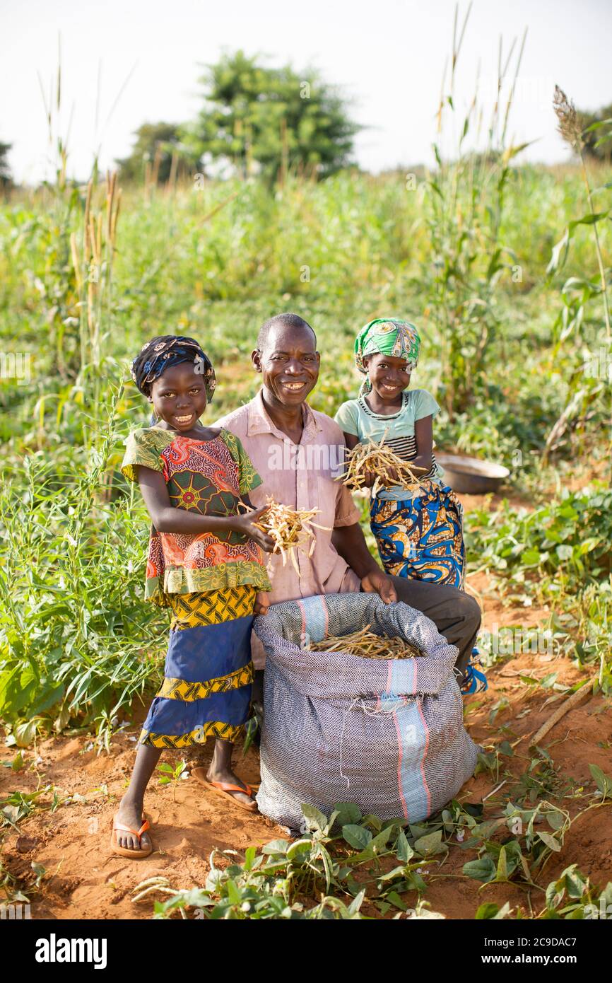 Portrait of a farmer family with their cowpea harvest in Tahoua Region, Niger, West Africa. Stock Photo