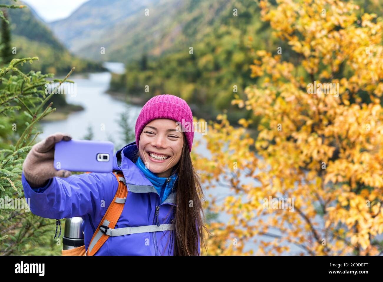 Happy asian hiker woman taking smartphone selfie at scenic viewpoint in ...