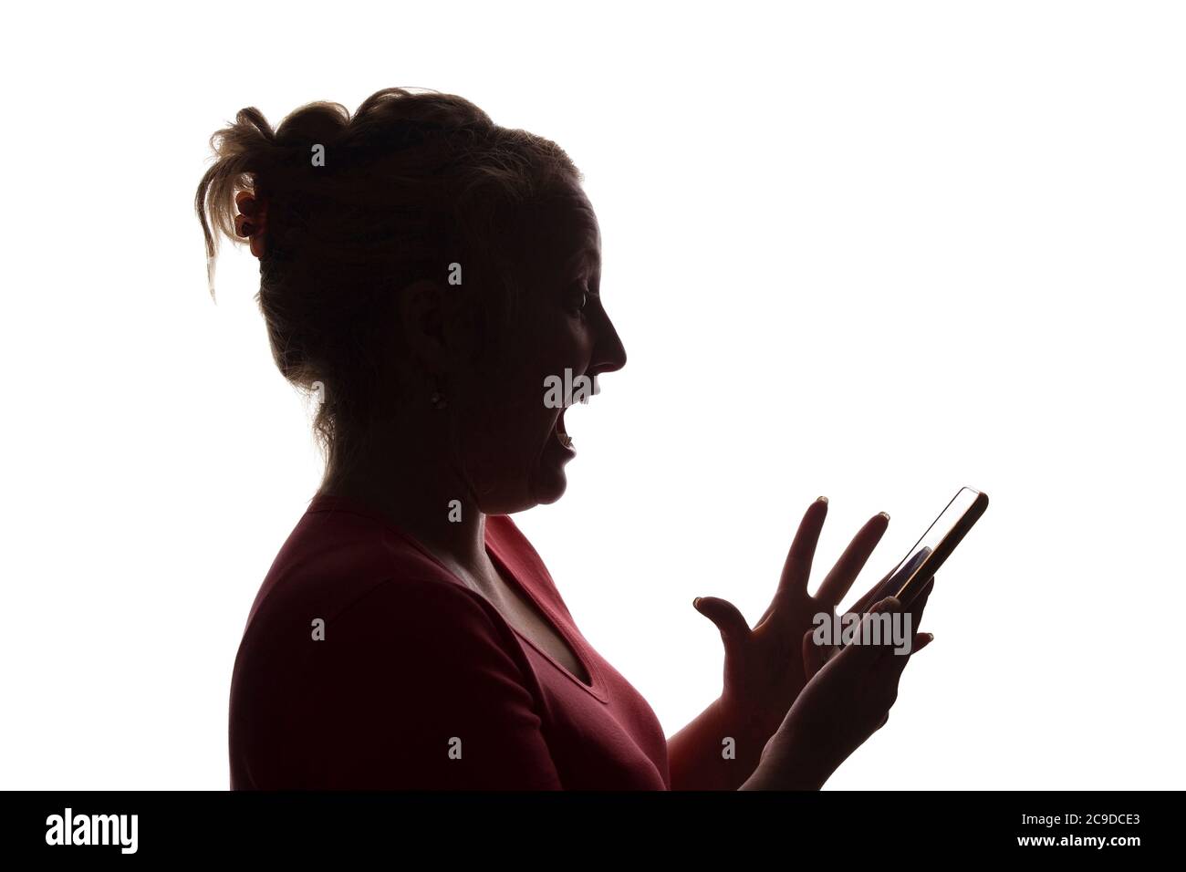 Silhouette of a surprise exclamation girl with a mobile smart phone - isolated, technology Stock Photo