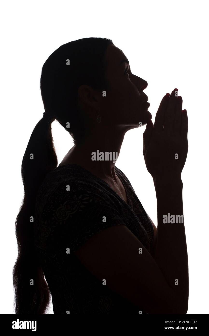 Young woman looking up with hope and request - silhouette of a side view Stock Photo