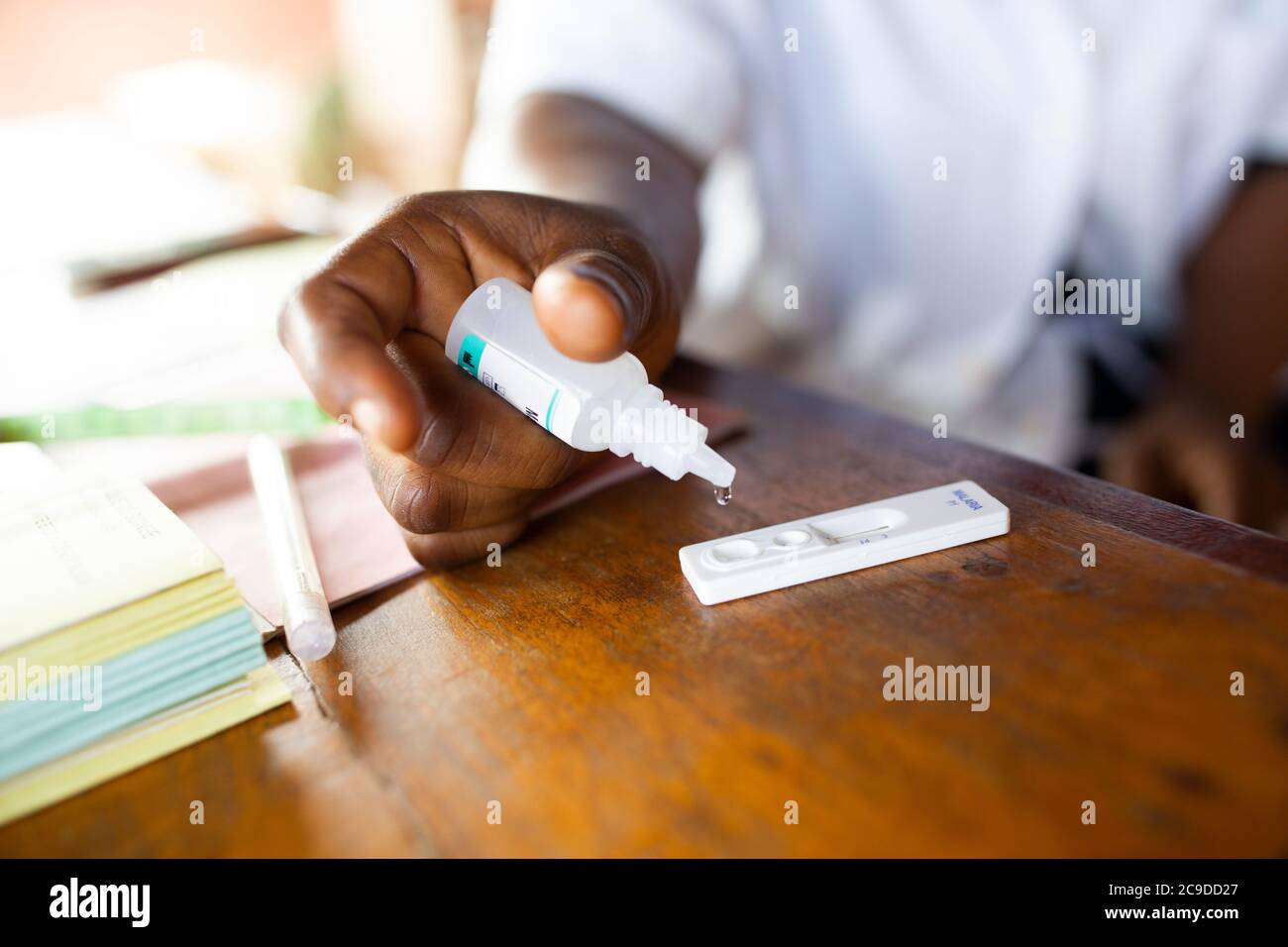 A nurse administers a rapid malaria test at a health center in Kouroussa, Guinea, West Africa. Stock Photo