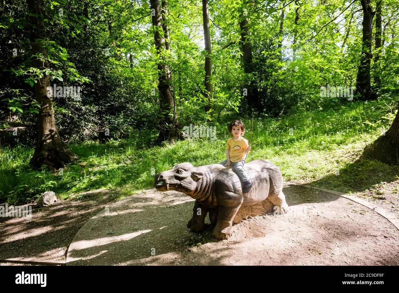 A wooden sculpture of a prehistoric Coryphodon At Lesnes Abbey Wood Fossil Park. Stock Photo