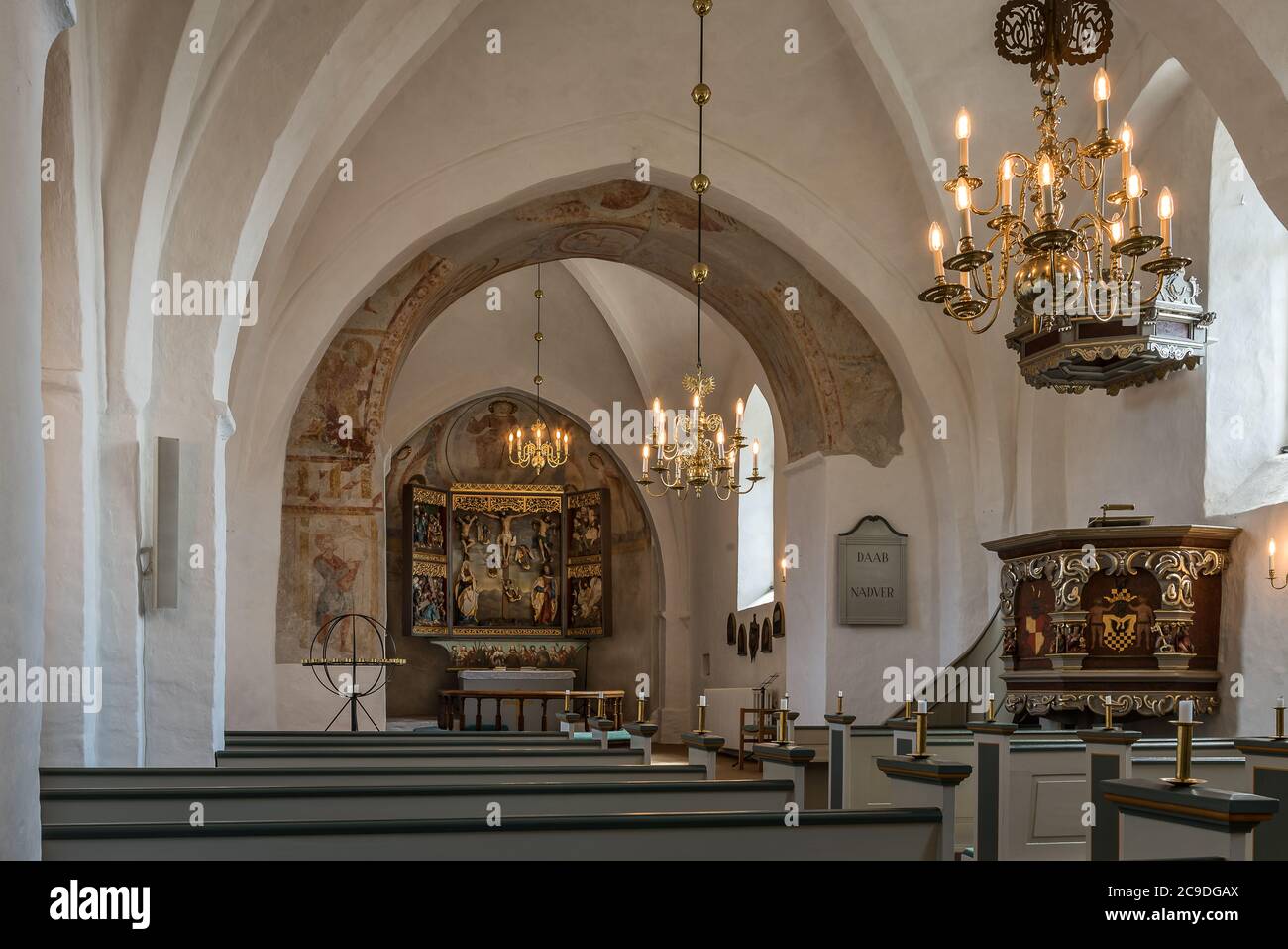 interior of an medeival danish church with glowing chandeliers, Hagested, Denmark, July 16, 2020 Stock Photo