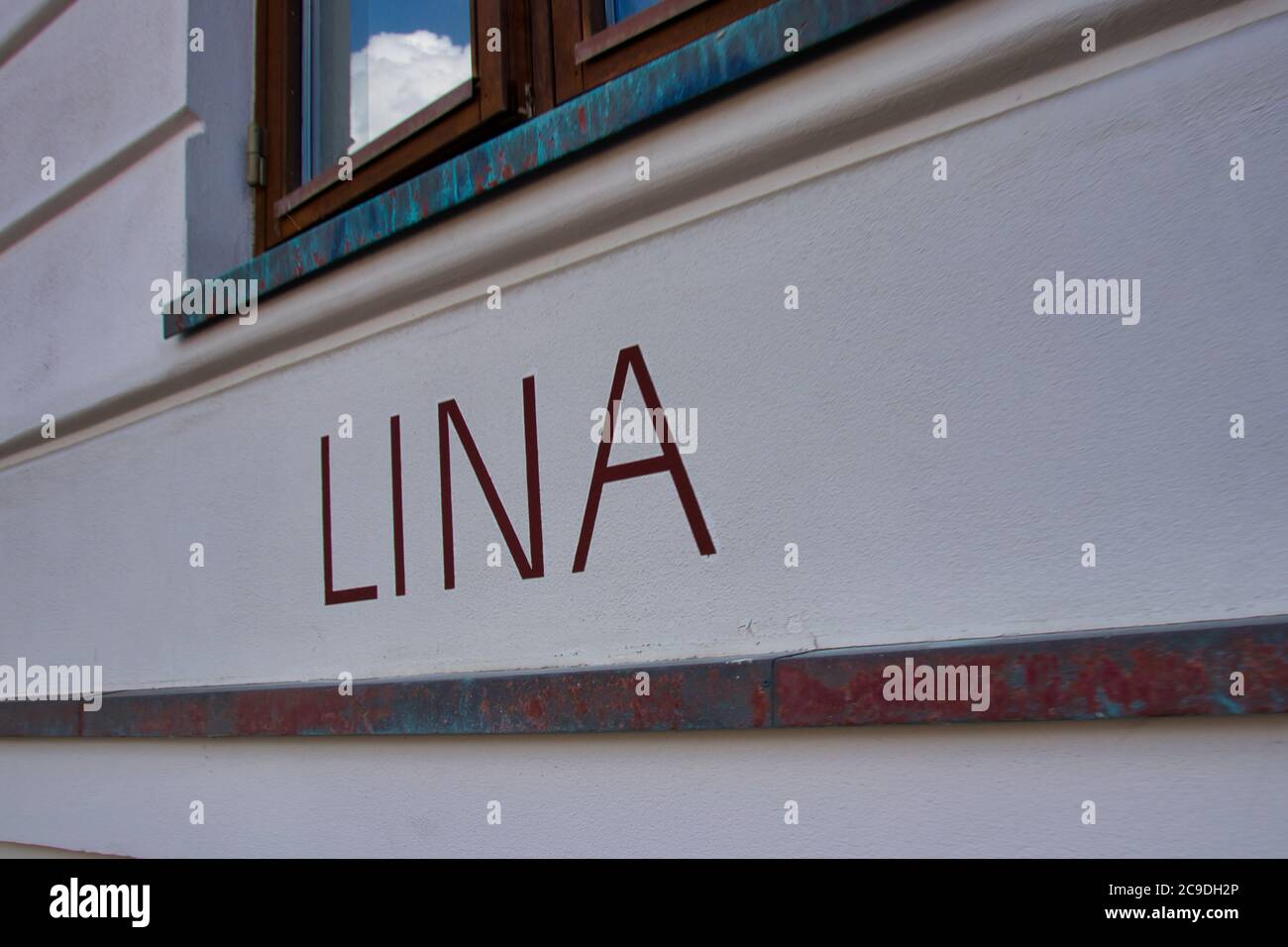 LINA lettering on a house wall with a window Stock Photo