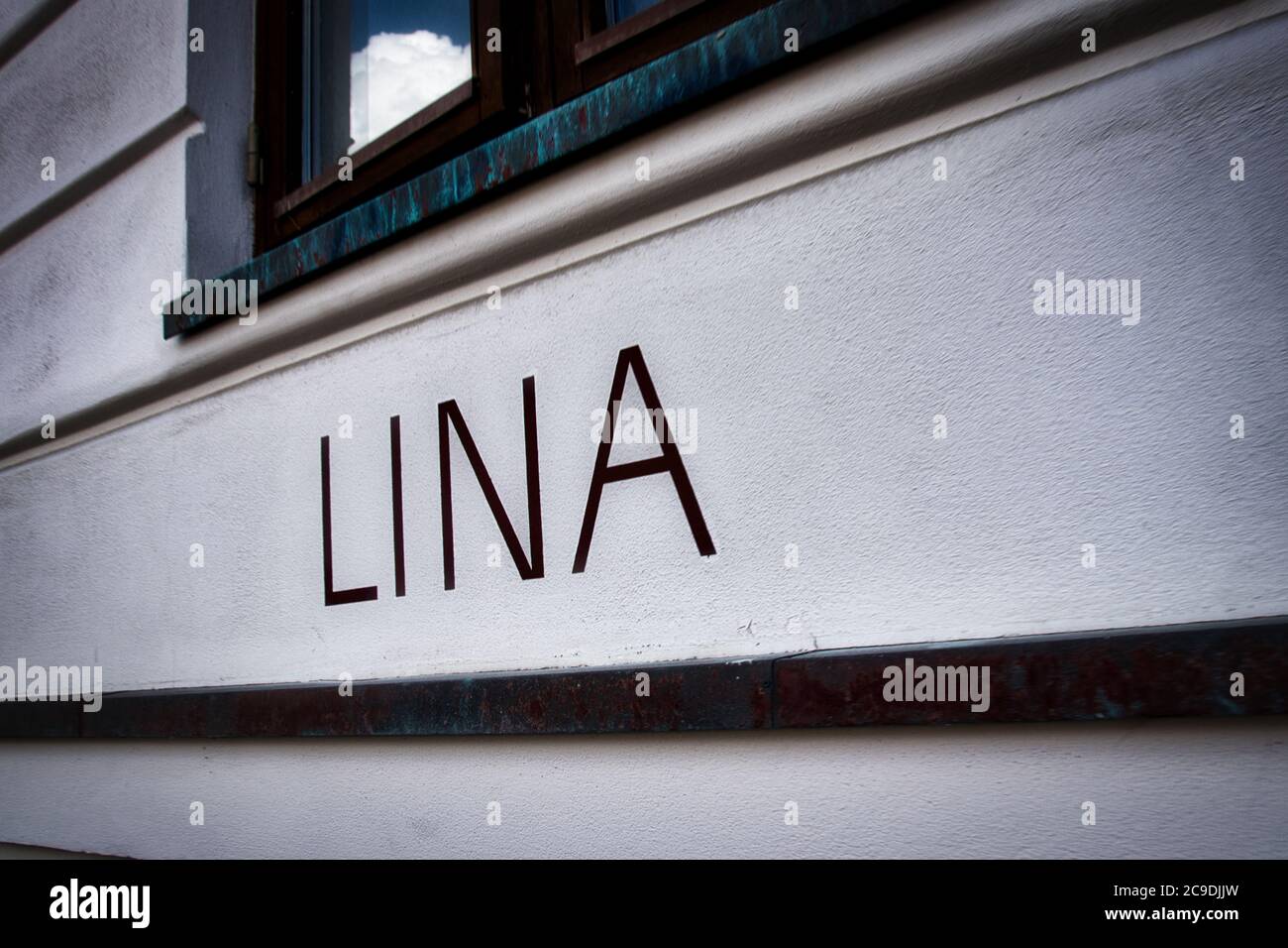 LINA lettering on a house wall with a window Stock Photo