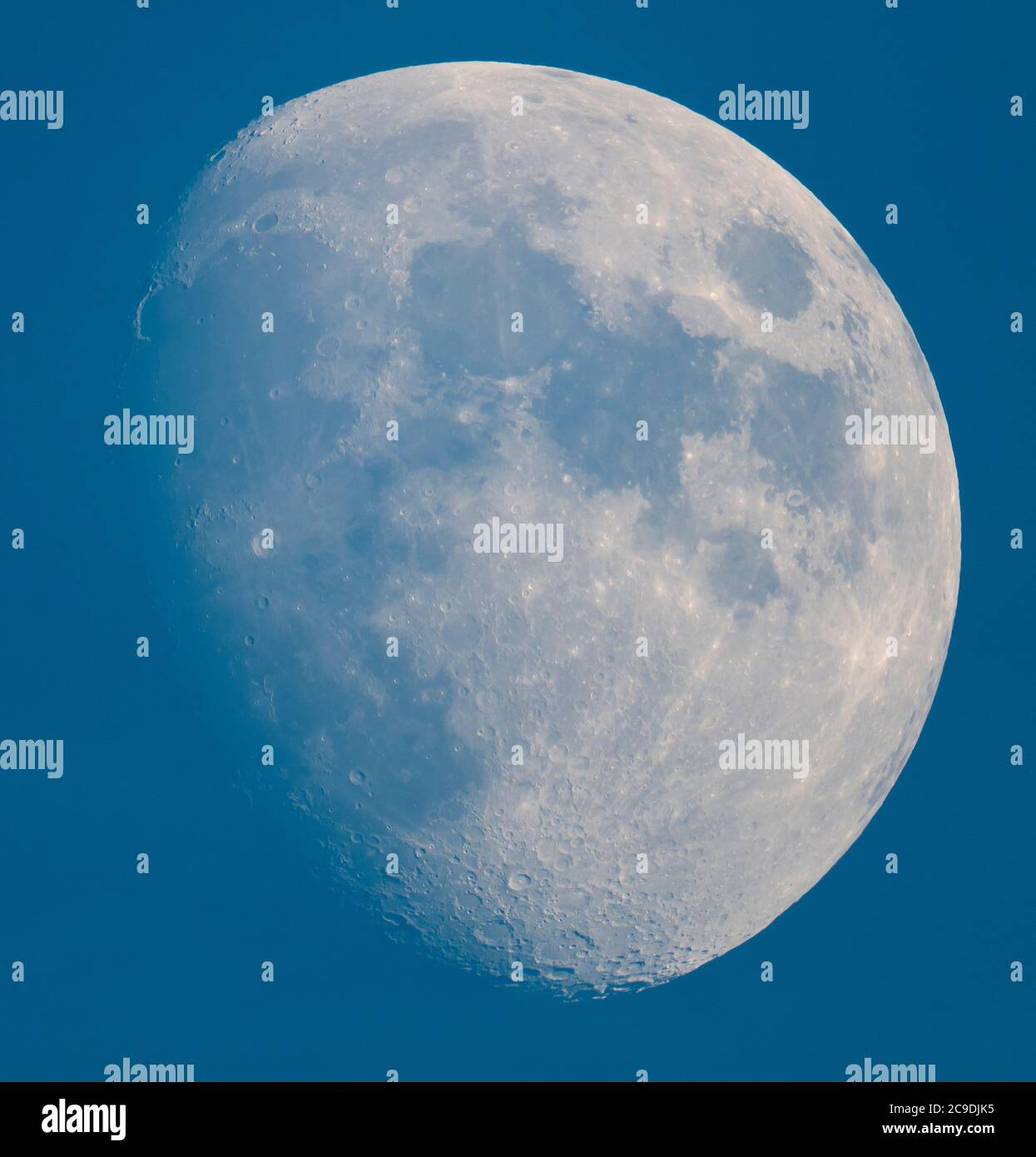 London, UK. 30 July 2020. An 84% illuminated Waxing Gibbous Moon above London in blue sky and a clear atmosphere, photographed through a telescope, showing crater detail on the south lunar pole. Credit: Malcolm Park/Alamy Live News Stock Photo