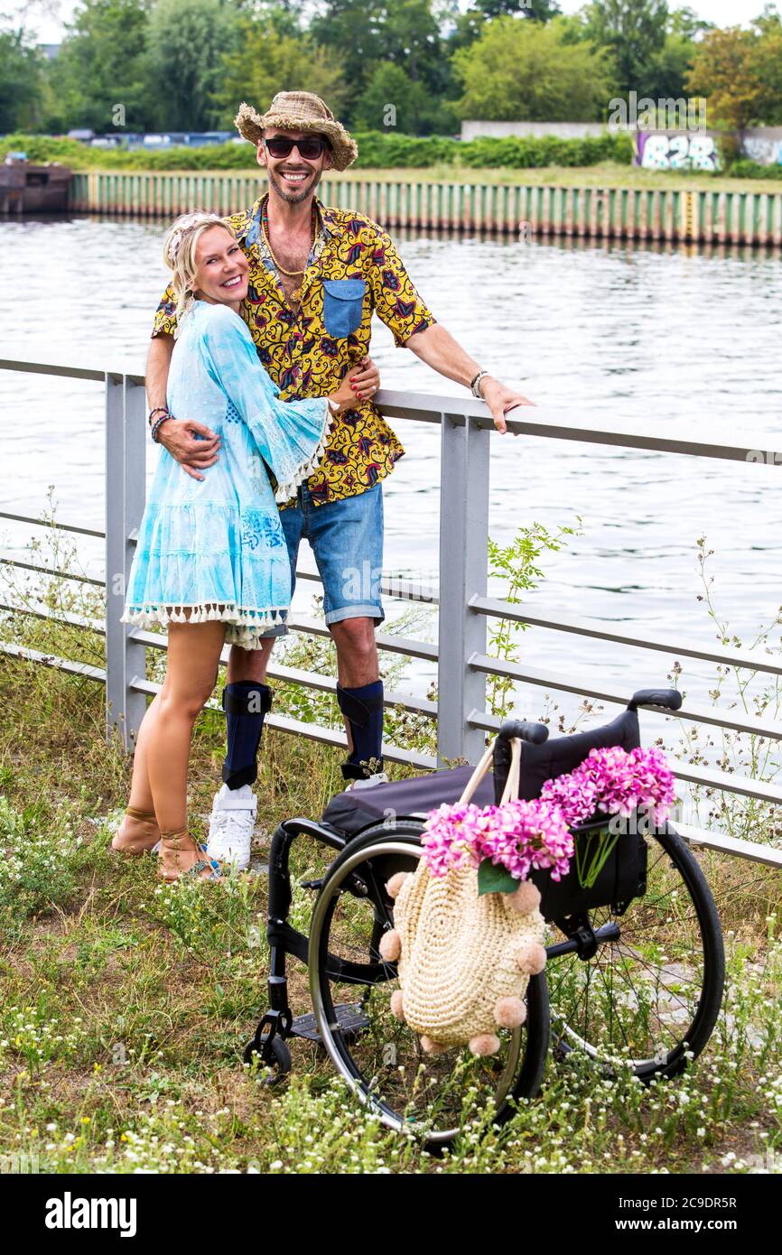 blond woman holding man standing by a river next to a wheelchair Stock ...