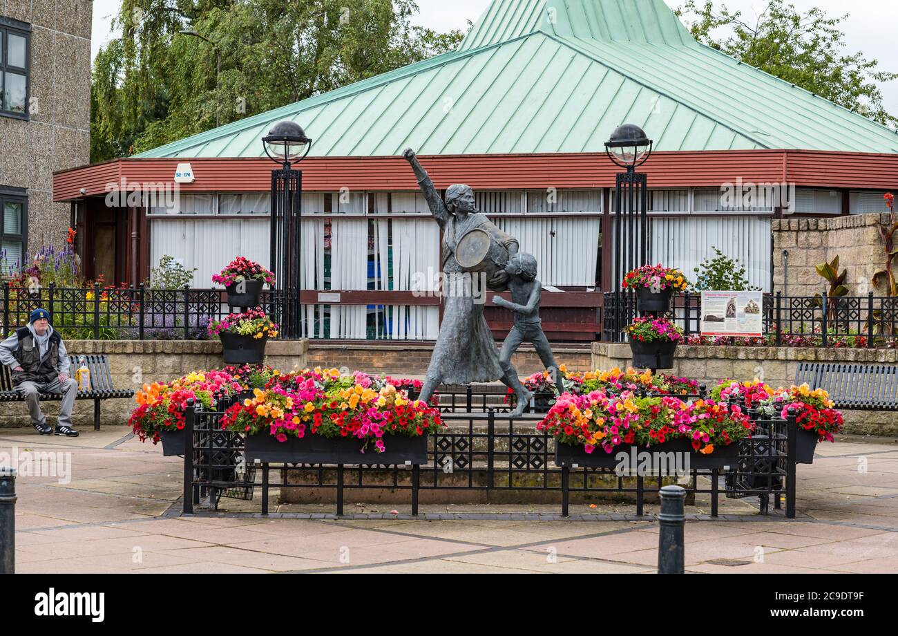 Jackie Crookston memorial statue (David Annand), Tranent, East Lothian, Scotland, UK with Keep Scotland Beautiful flowers Stock Photo
