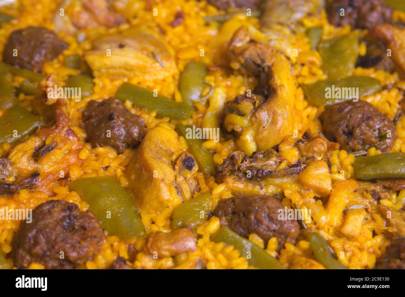 Detail of a freshly prepared rice paella with meat, vegetables and meatballs Stock Photo