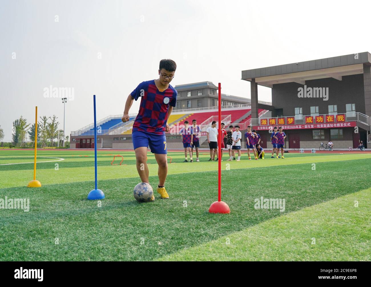 Renqiu, China's Hebei Province. 30th July, 2020. A student player participates in a school football team training session on the playground at Renqiu School Affiliated to Beijing Normal University in Renqiu City, north China's Hebei Province, July 30, 2020. Credit: Mu Yu/Xinhua/Alamy Live News Stock Photo