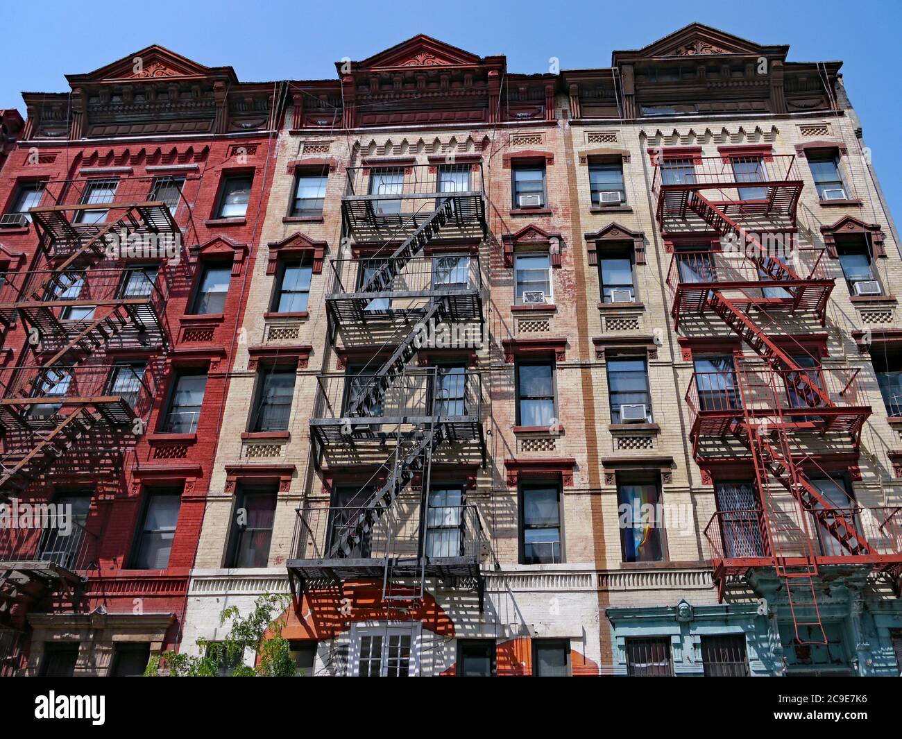 New York City, colorful old fashioned apartment buildings with external fire ladders Stock Photo