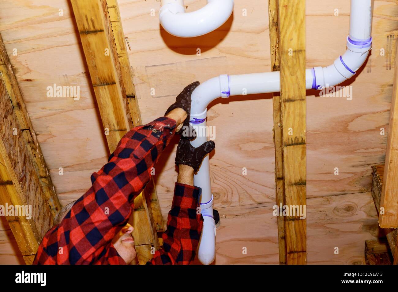 Workers are sewer toilet pipes with PVC joints allows the split the make PVC pipe coming out the other side the buildingceiling beam house. soft focus Stock Photo