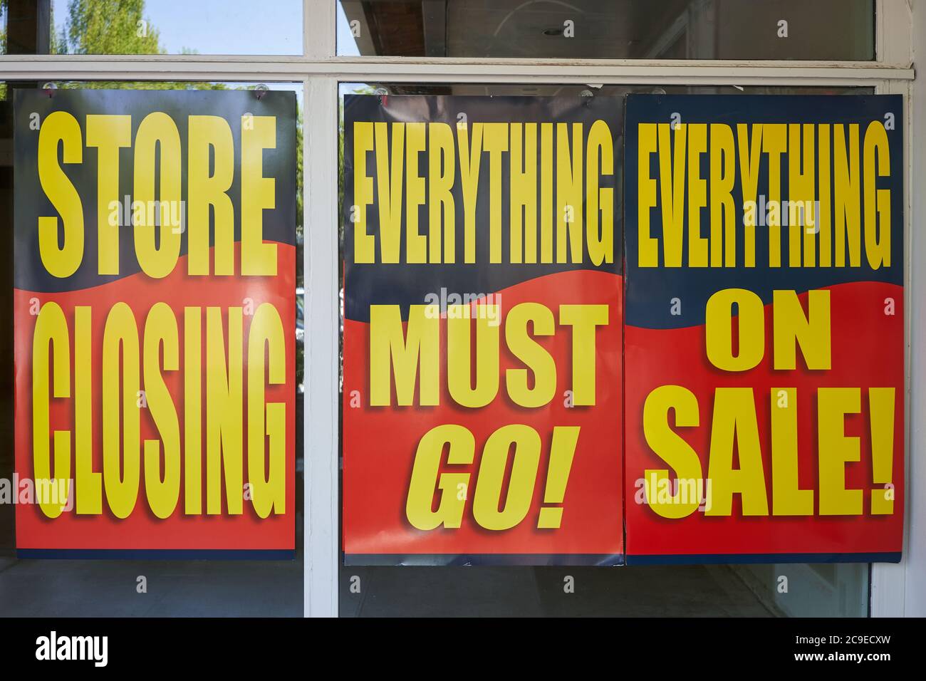 Large printed signs at a closing retail store. Liquidation sale posters at the storefront. Stock Photo