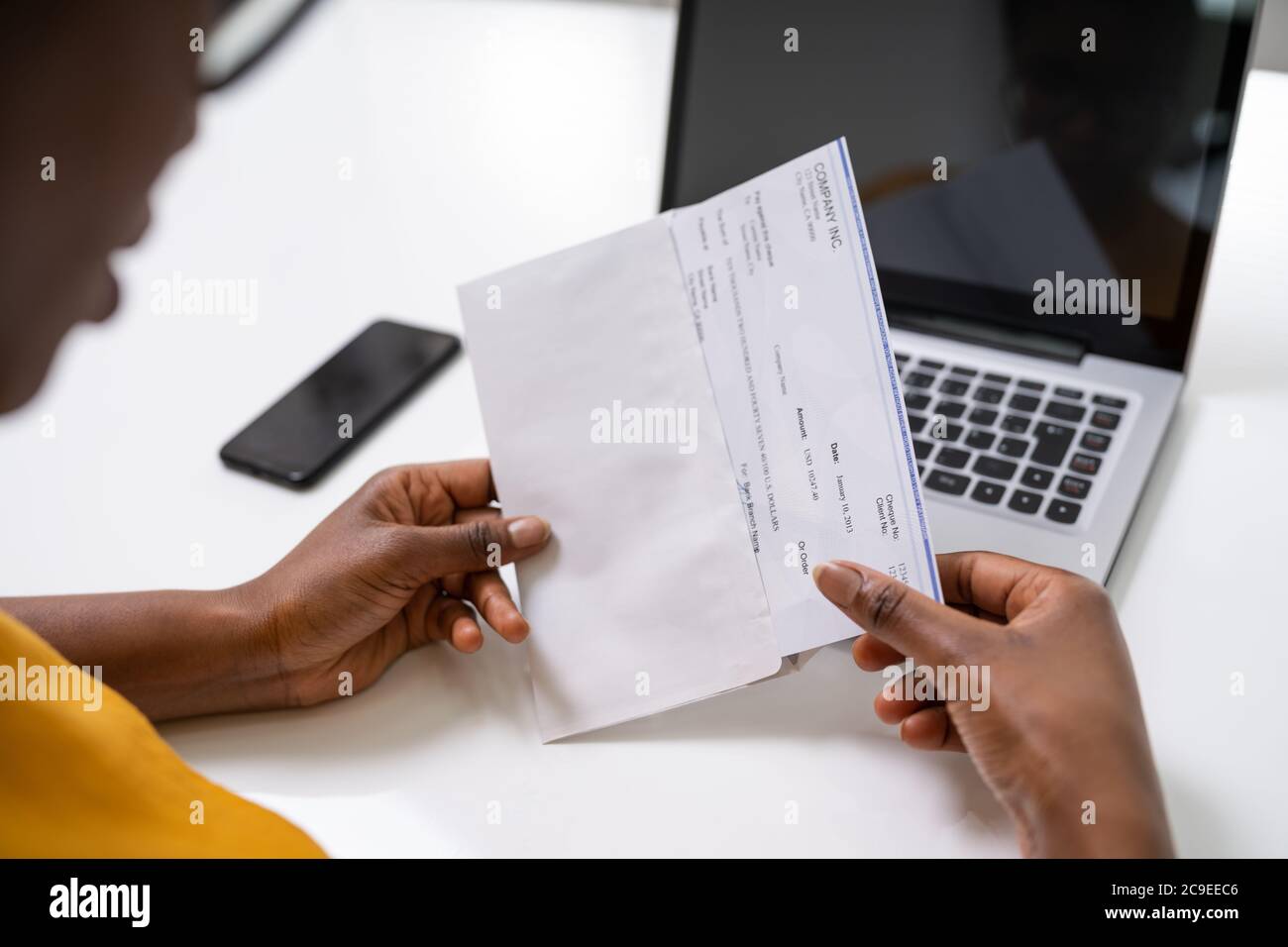 American African Holding Paycheck Or Payroll Check Stock Photo