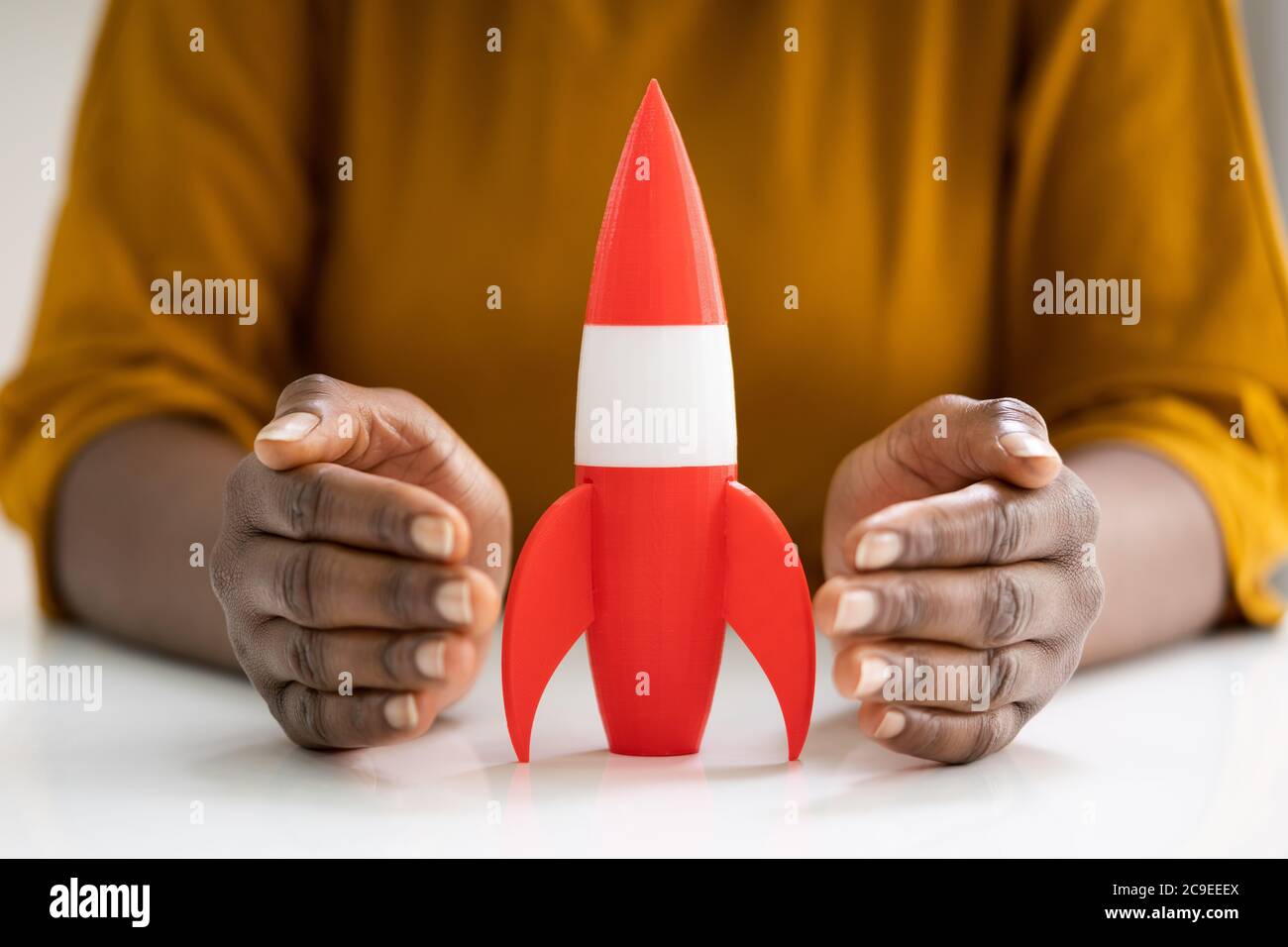 Woman Hands Protecting Red Rocket Launch. Speed Start Stock Photo