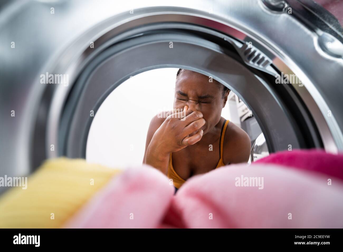 Broken Smelly Washing Machine. Woman Washing Towel Stock Photo