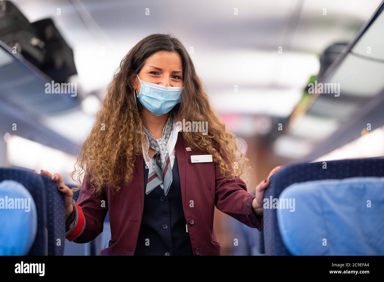 Stuttgart, Germany. 31st July, 2020. A train attendant dressed in the new clothes of Deutsche Bahn is standing in an ICE train travelling from Stuttgart to the Baltic resort of Binz. The clothing was created by the designer Guido Maria Kretschmer. Credit: Sebastian Gollnow/dpa/Alamy Live News Stock Photo