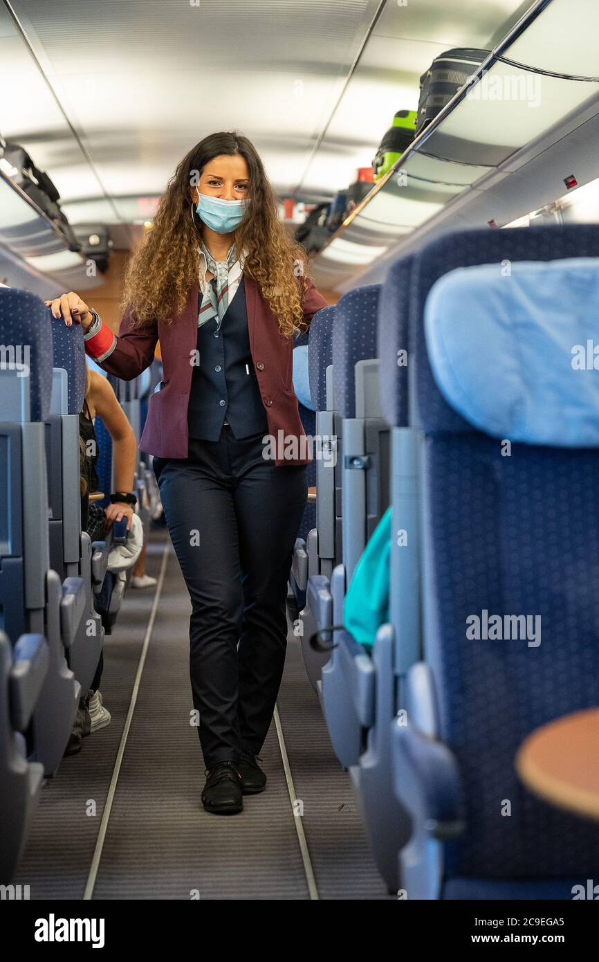Stuttgart, Germany. 31st July, 2020. A train attendant dressed in the new clothes of Deutsche Bahn is standing in an ICE train travelling from Stuttgart to the Baltic resort of Binz. The clothing was created by the designer Guido Maria Kretschmer. Credit: Sebastian Gollnow/dpa/Alamy Live News Stock Photo